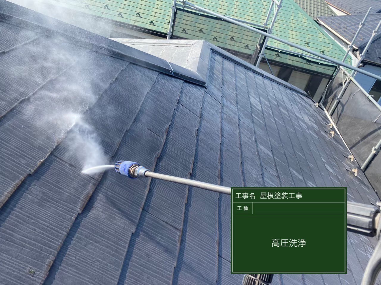 強力な高圧洗浄機でスレート屋根を掃除。古い塗膜や汚れを根こそぎ落とし、新しい塗料の密着性を高めるための重要な下準備です。